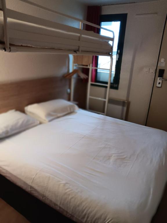 een bed in een kamer met een stapelbed bij HOTEL PREMIERE CLASSE Rouen Sud Oissel in Saint-Étienne-du-Rouvray