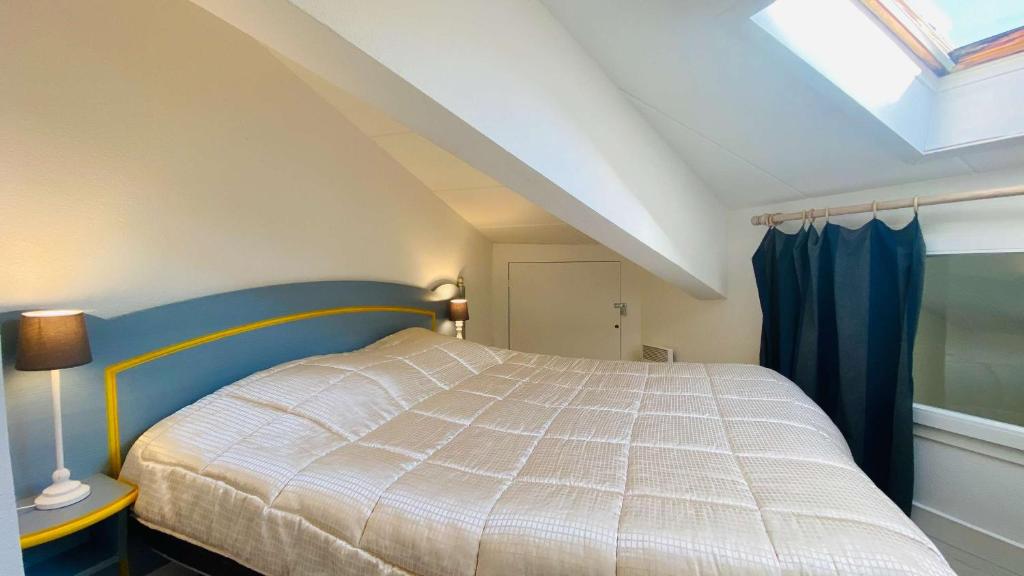 a bedroom with a bed and a skylight at Appartement dans résidence avec piscine proche plage et commerces in La Couarde-sur-Mer
