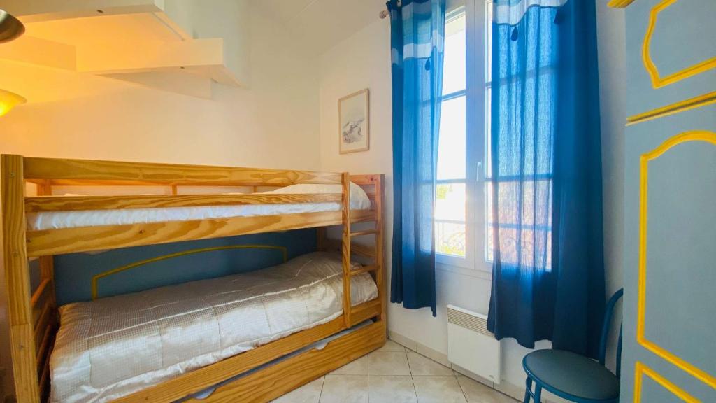 two bunk beds in a room with a window at Appartement dans résidence avec piscine proche plage et commerces in La Couarde-sur-Mer