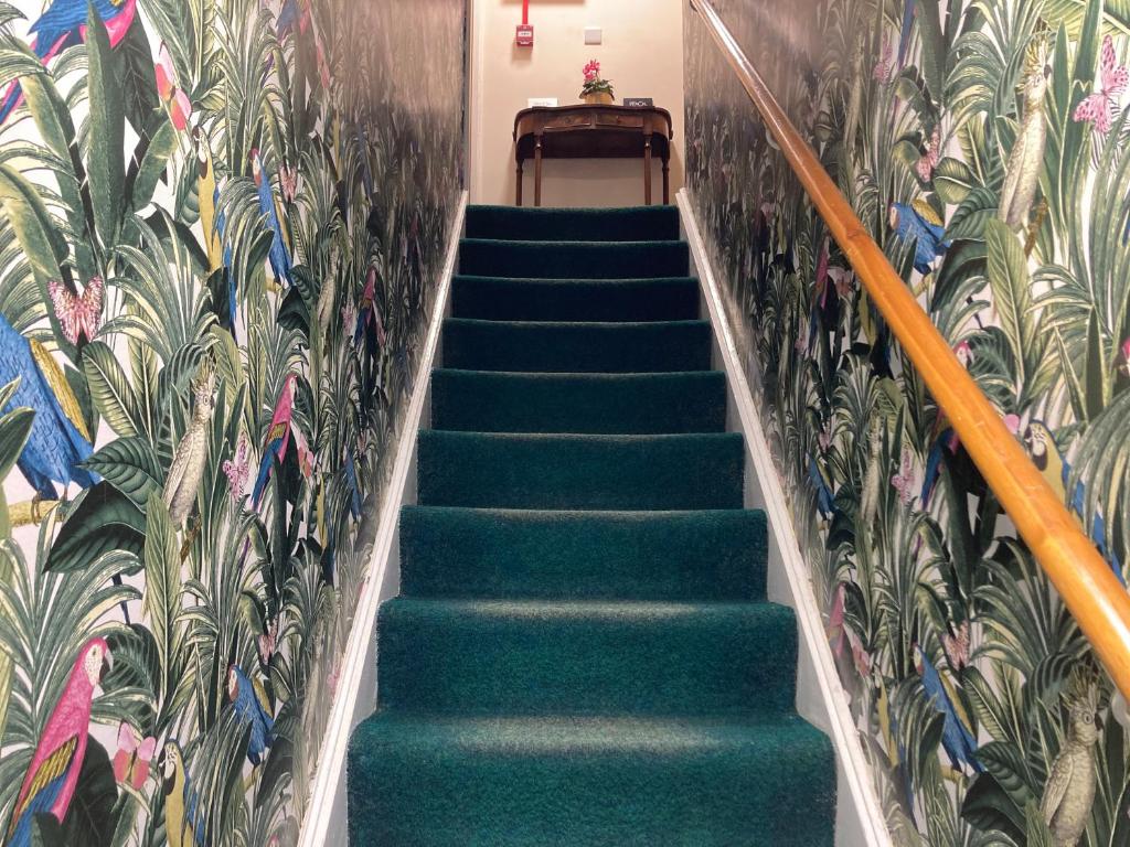 eine Treppe mit grünen Treppen und eine Wand mit Pflanzen in der Unterkunft The Sheep Loft in Lincolnshire