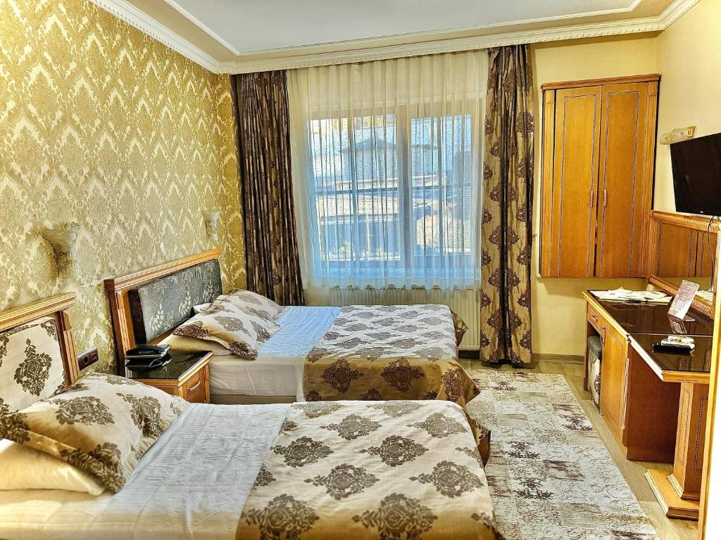 a hotel room with two beds and a window at Grand Papirus Hotel in Istanbul