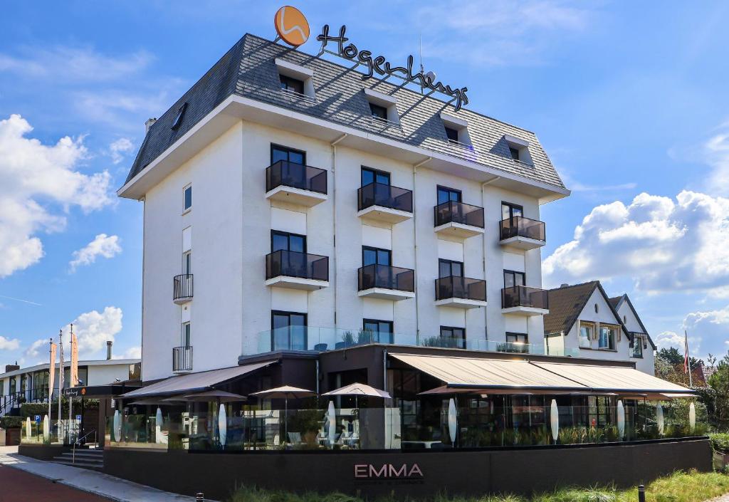 un grand bâtiment blanc avec un toit dans l'établissement Hotel Hogerhuys - adults only, à Noordwijk aan Zee