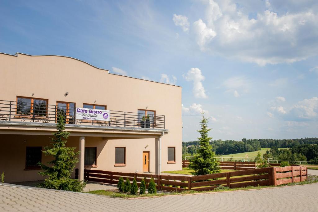 a building with a balcony on the side of it at Lascalla pensjonat in Myszewko