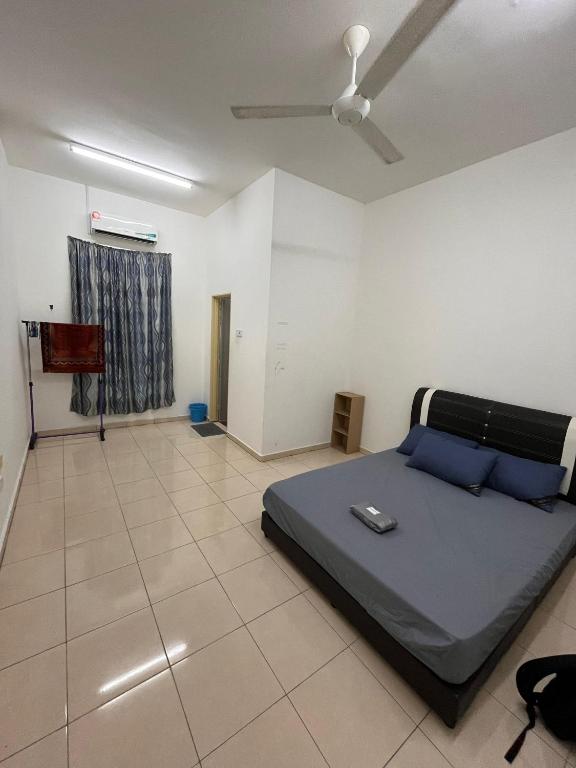 a bedroom with a bed and a ceiling fan at Zara Homestay in Marang
