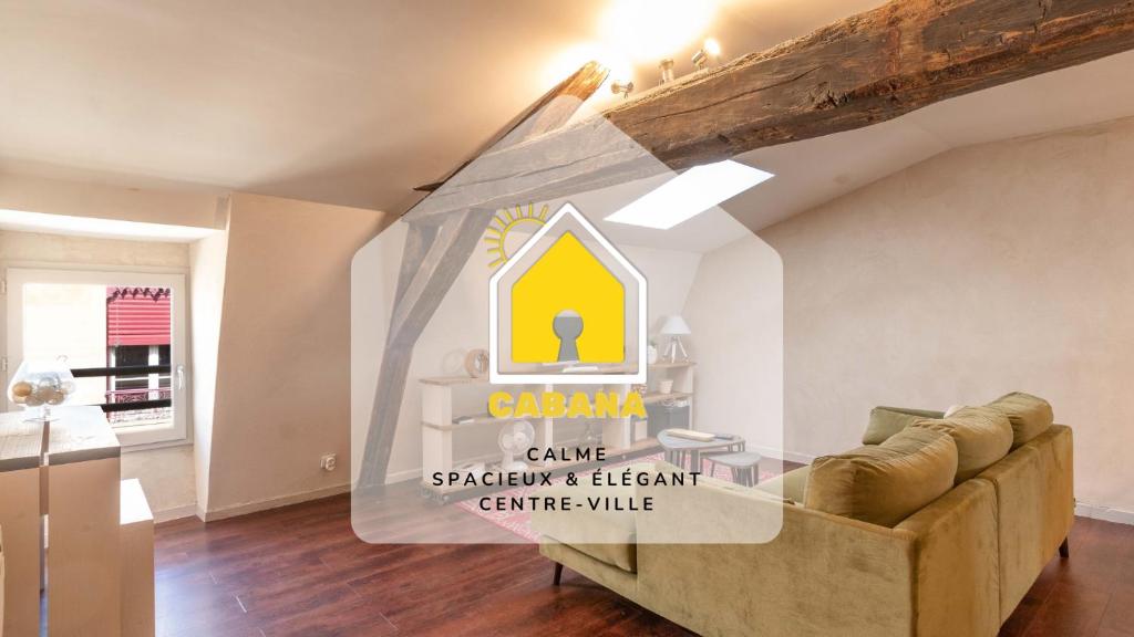 裙尼的住宿－Cabana & Le Chaleureux - Centre-Ville，客厅配有沙发和墙上的标志