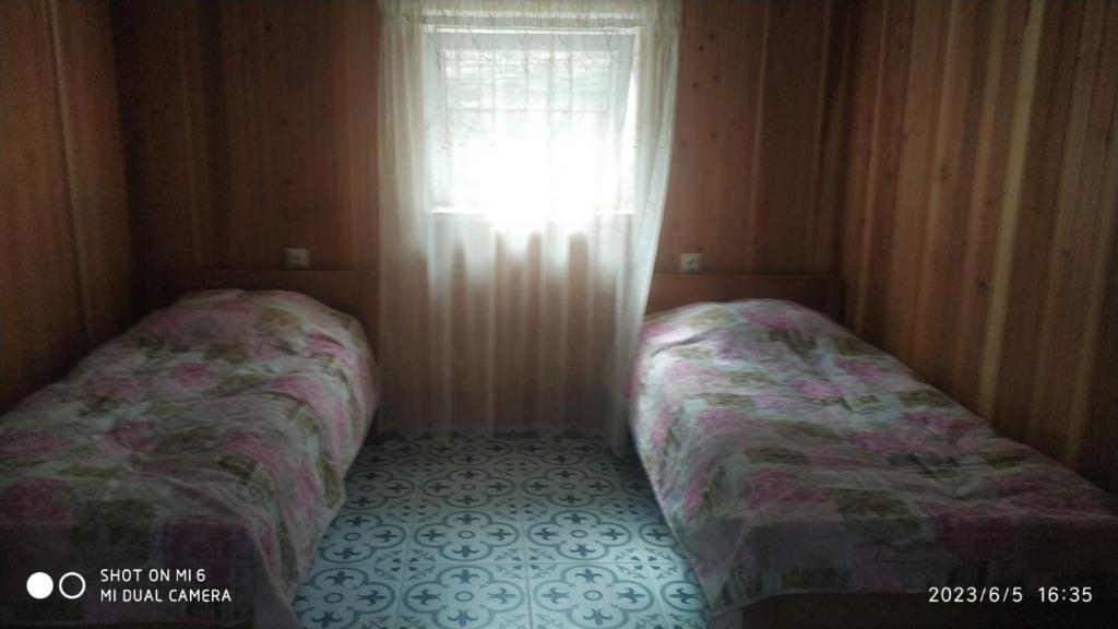 - 2 lits dans une petite chambre avec fenêtre dans l'établissement Family Holiday, à Kobuleti