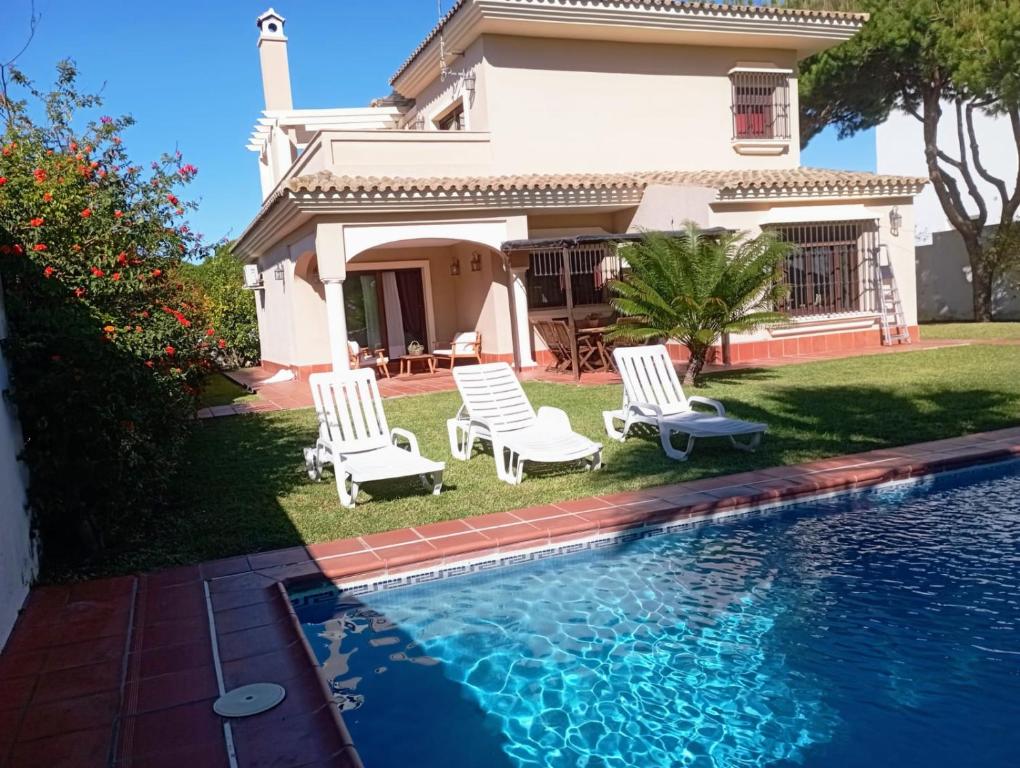 una casa con 2 sillas y una piscina en Villa Martiniano, en Campano