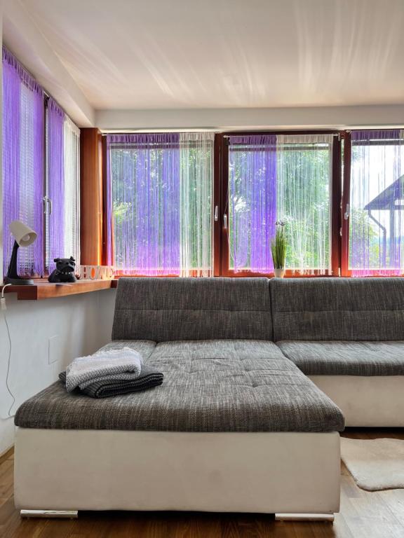 ein Schlafzimmer mit lila Vorhängen und einem großen Sofa in der Unterkunft KF Best Place in Knittelfeld