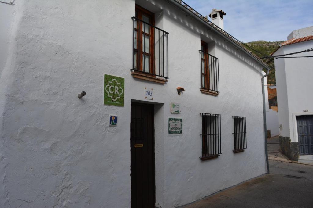 a white building with a black door and windows at La Carrihuela Amarilla in Algodonales