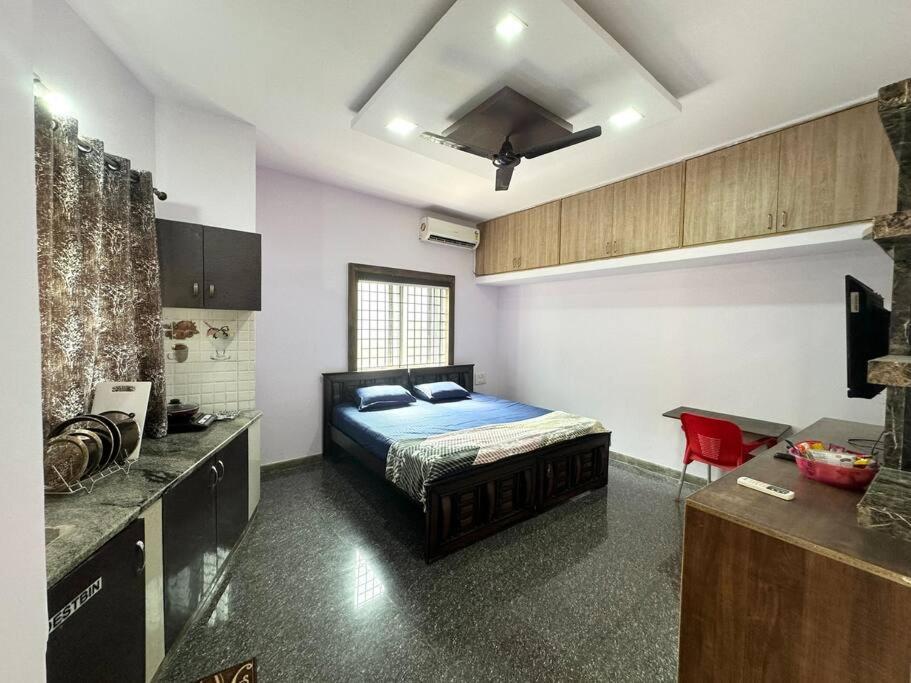 een slaapkamer met een bed in een kamer met een keuken bij Amazing AC Studio in E City 3F 301 in Bangalore