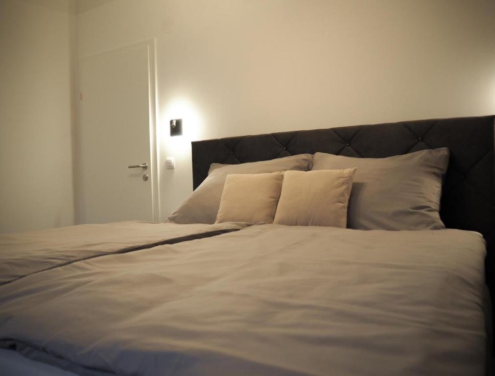 a large bed with white sheets and pillows at Loft Schottenau in Neusiedl am See
