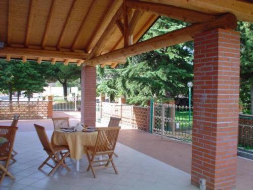 a patio with a table and chairs under a pavilion at Il Vigneto in Trecastagni