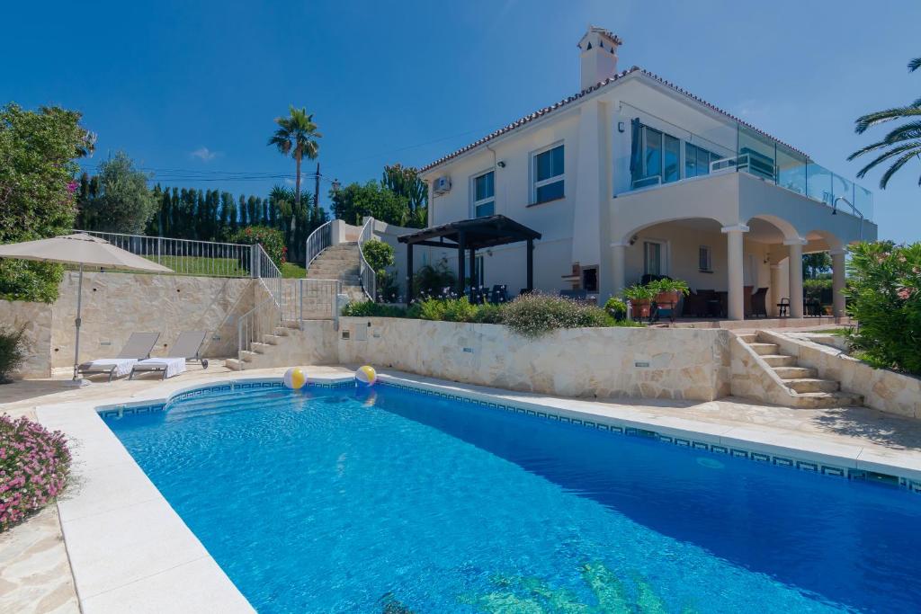 a house with a swimming pool in front of a house at Villa Near Beach in Marbella with Heated Pool in Marbella