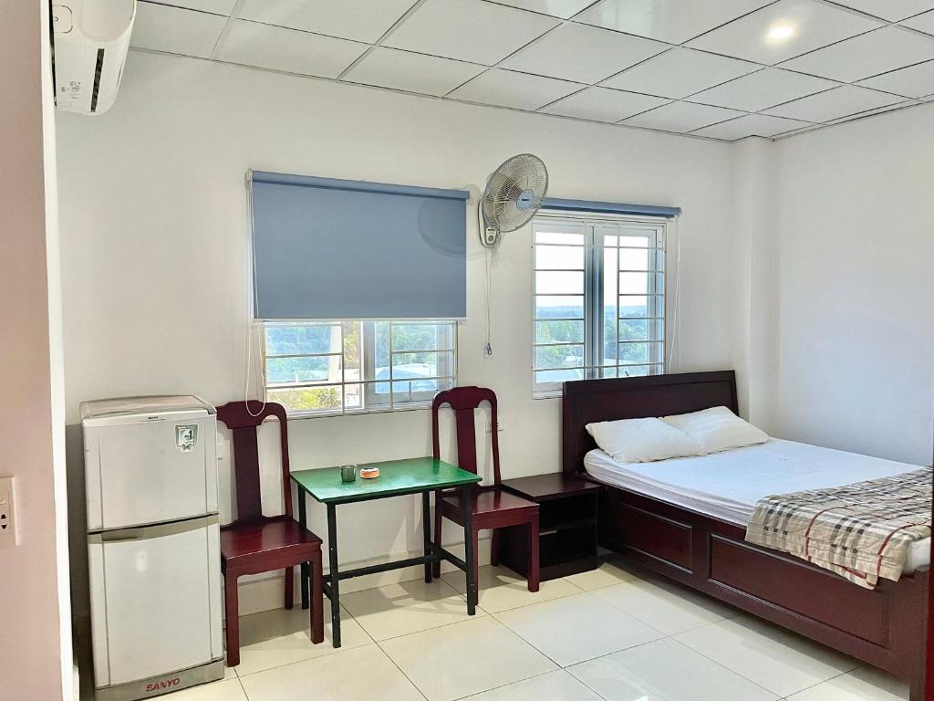 a bedroom with a bed and a table and chairs at Thuỷ Quỳnh hotel in Xóm Bên Ðông