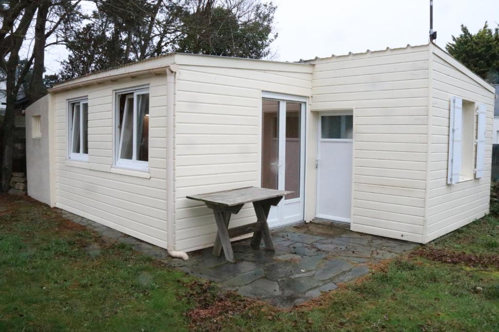 un hangar blanc avec un banc devant lui dans l'établissement maisonnette, à La Turballe