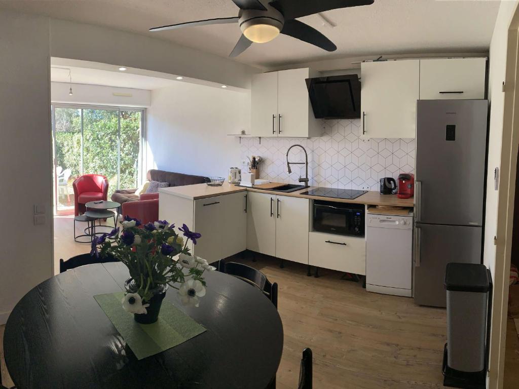 une cuisine et une salle à manger avec une table et une salle à manger dans l'établissement Charmant T3 rénové, jardin privatif, plage à pied, clim, parking, 4 pers. - FR-1-607-153, au Cap d'Agde