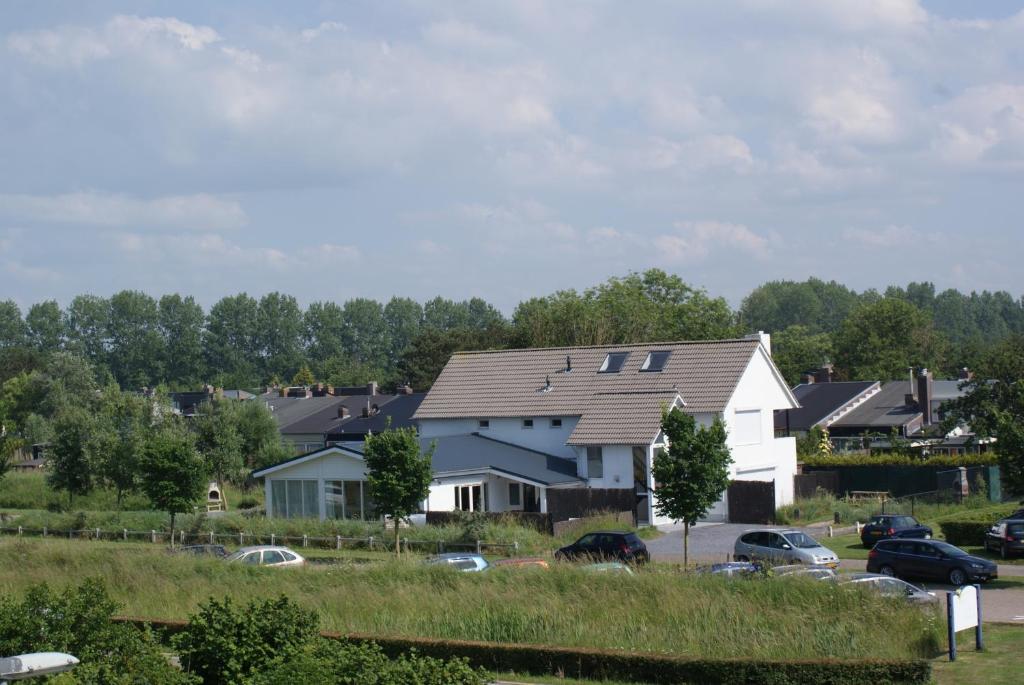 une grande maison blanche avec un toit en gambrel dans l'établissement La Cabane Penthouse, à Nieuwvliet-Bad