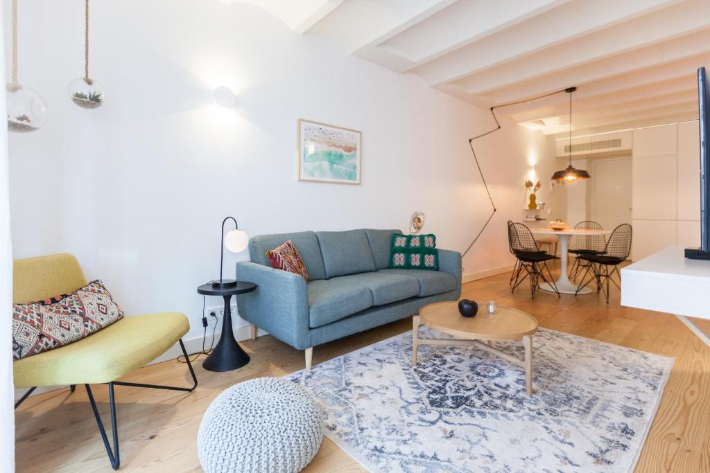 a living room with a blue couch and a table at FLH Bairro Alto Balcony with River View in Lisbon