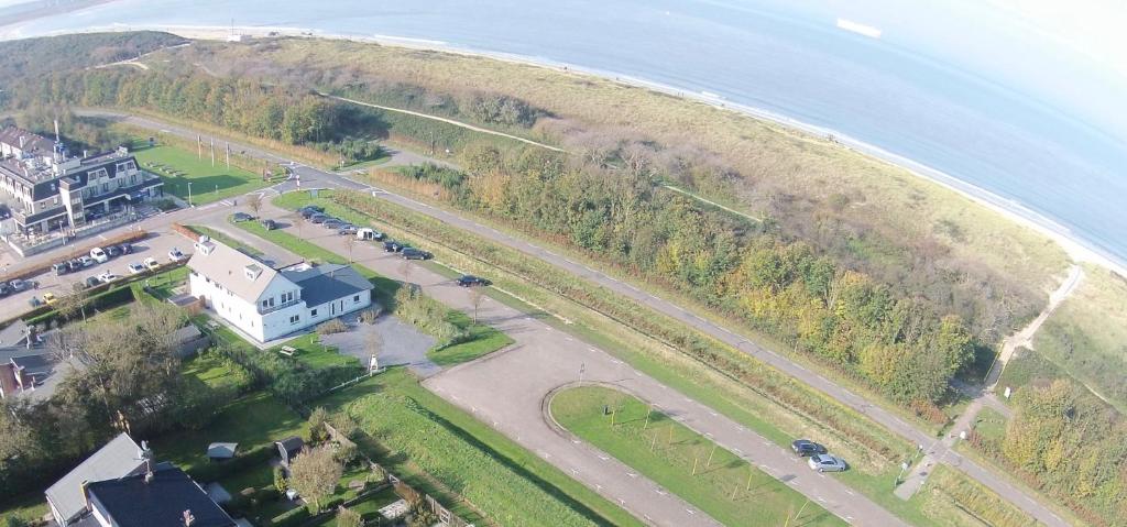 an aerial view of a road next to the ocean at La Cabane Penthouse in Nieuwvliet-Bad