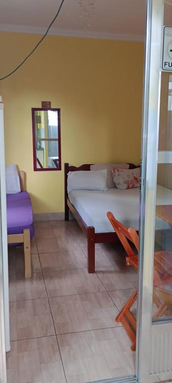 a bedroom with a bed and a chair and a mirror at Alta Vista in Penedo