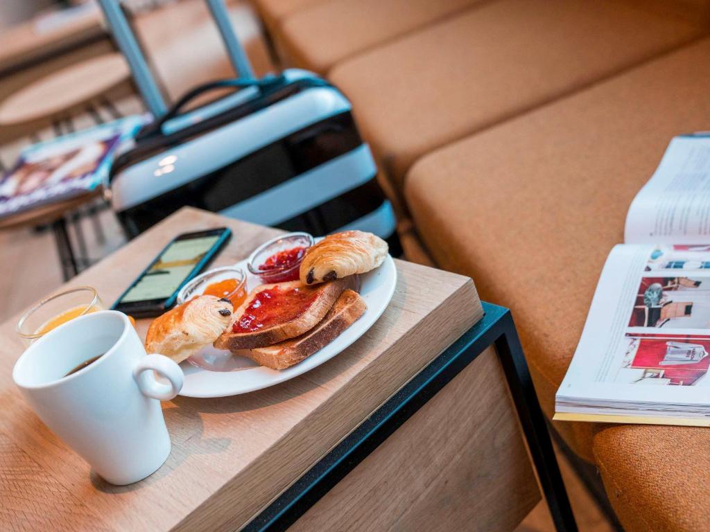 - un plateau de pâtisseries et une tasse de café sur une table dans l'établissement Ibis Styles Paris Place d'Italie - Butte Aux Cailles, à Paris