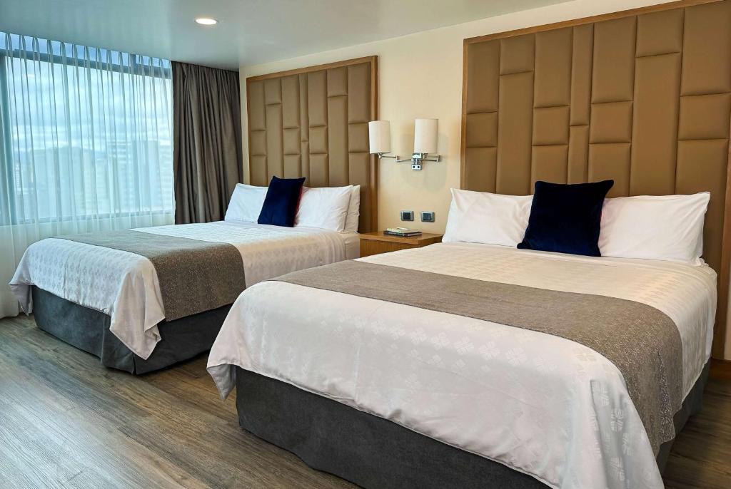 Cette chambre comprend 2 lits et une fenêtre. dans l'établissement Wyndham Garden Quito, à Quito