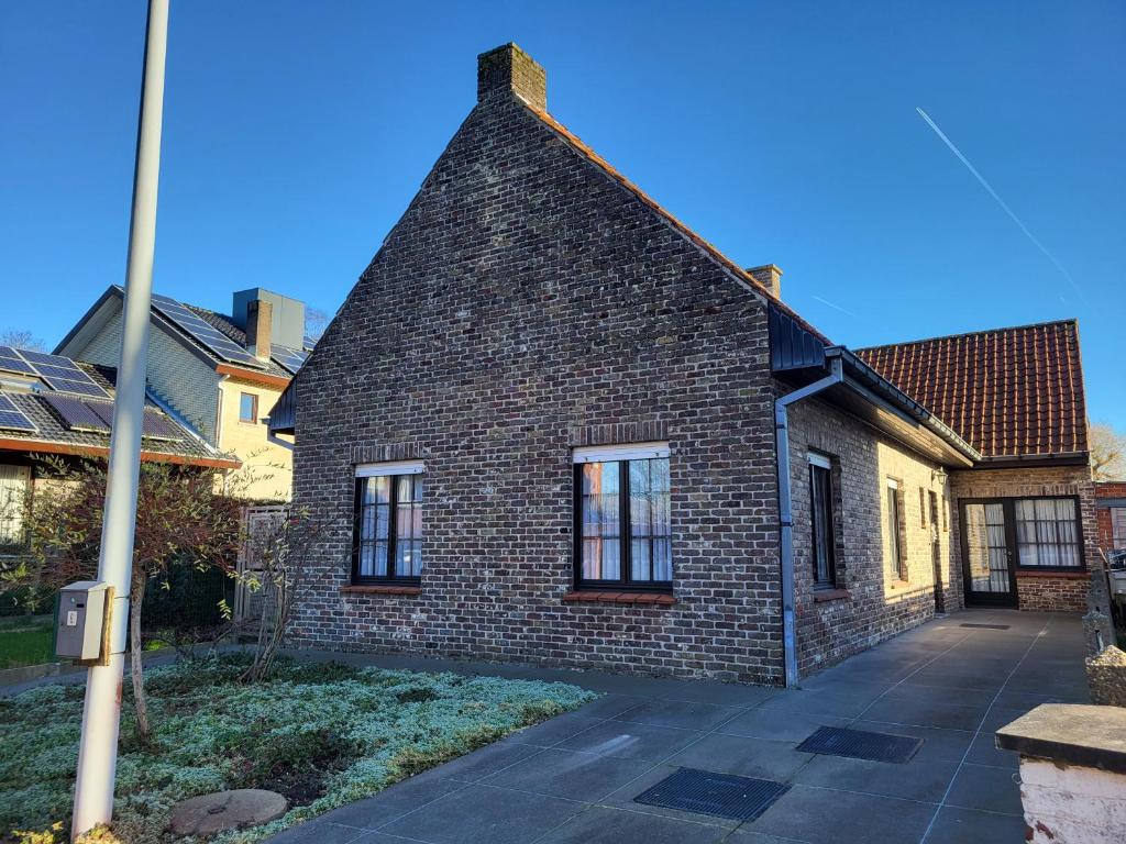 an old brick house with a roof at Leuke authentieke vakantiewoning voor 6 personen in Oedelem