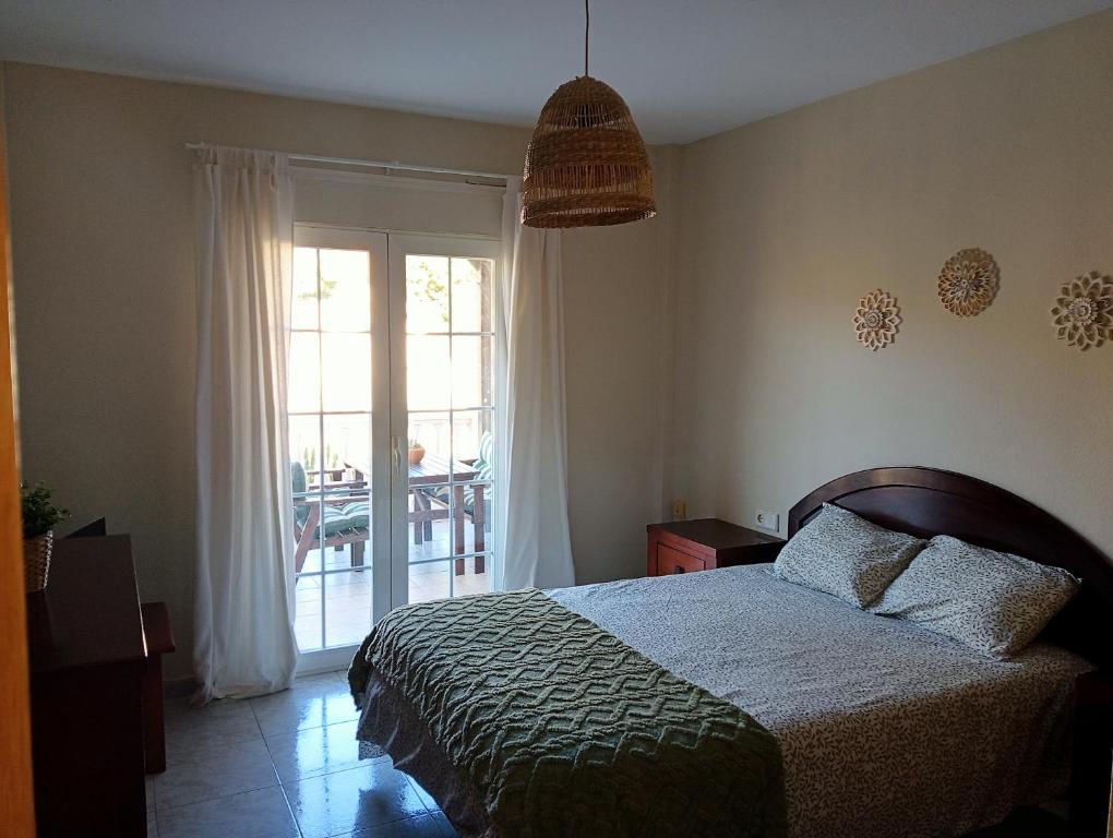 a bedroom with a bed and a sliding glass door at Balcón al mar in Adra