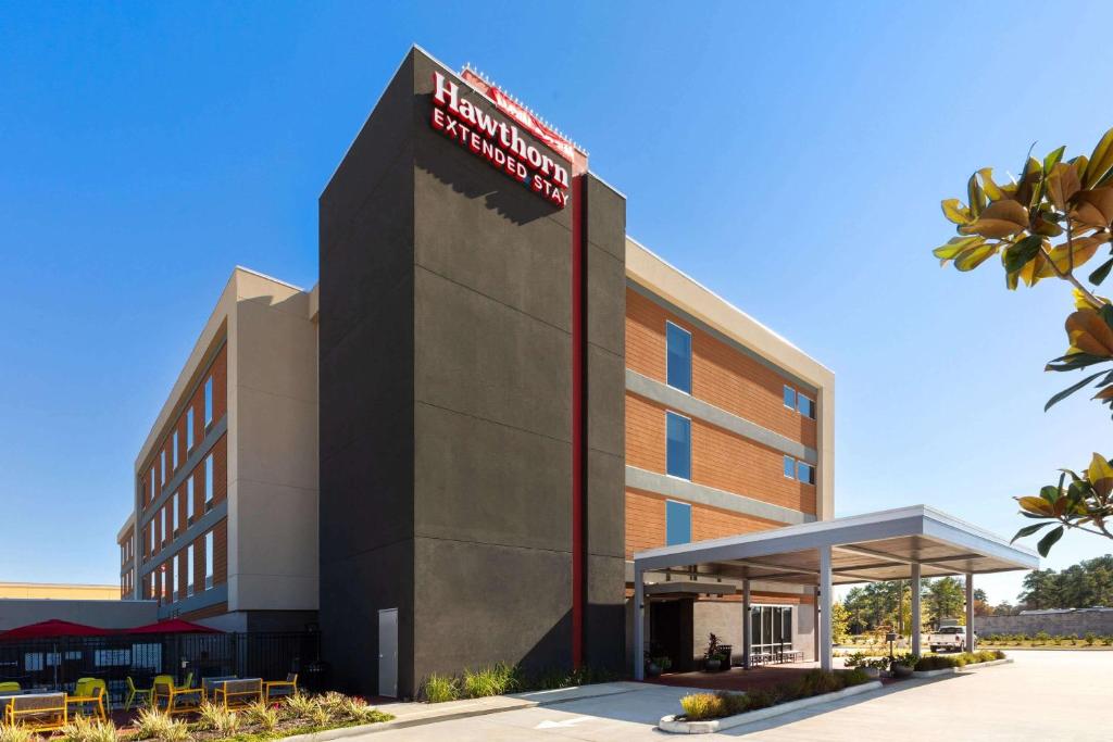 a rendering of the front of a hotel at Hawthorn Extended Stay by Wyndham Kingwood Houston in Kingwood