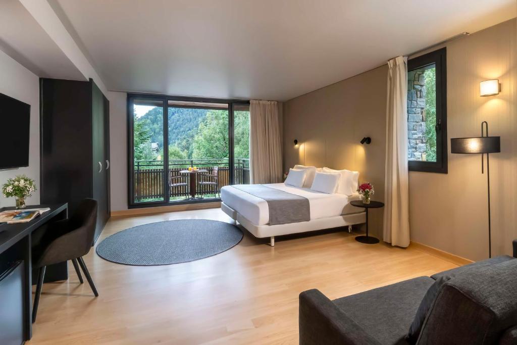 a bedroom with a bed and a large window at NH Collection Andorra Palomé in La Massana
