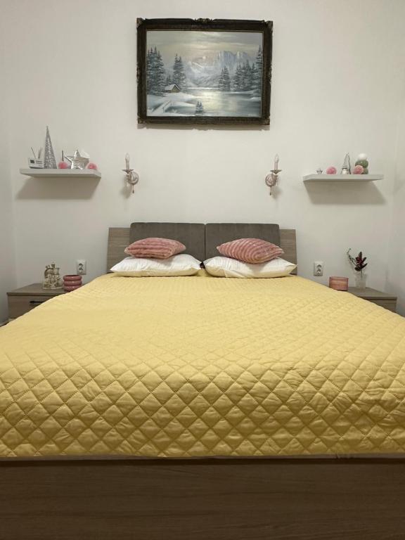 een bed met een geel dekbed en 2 kussens bij Cazare central Sinaia, Romania in Sinaia