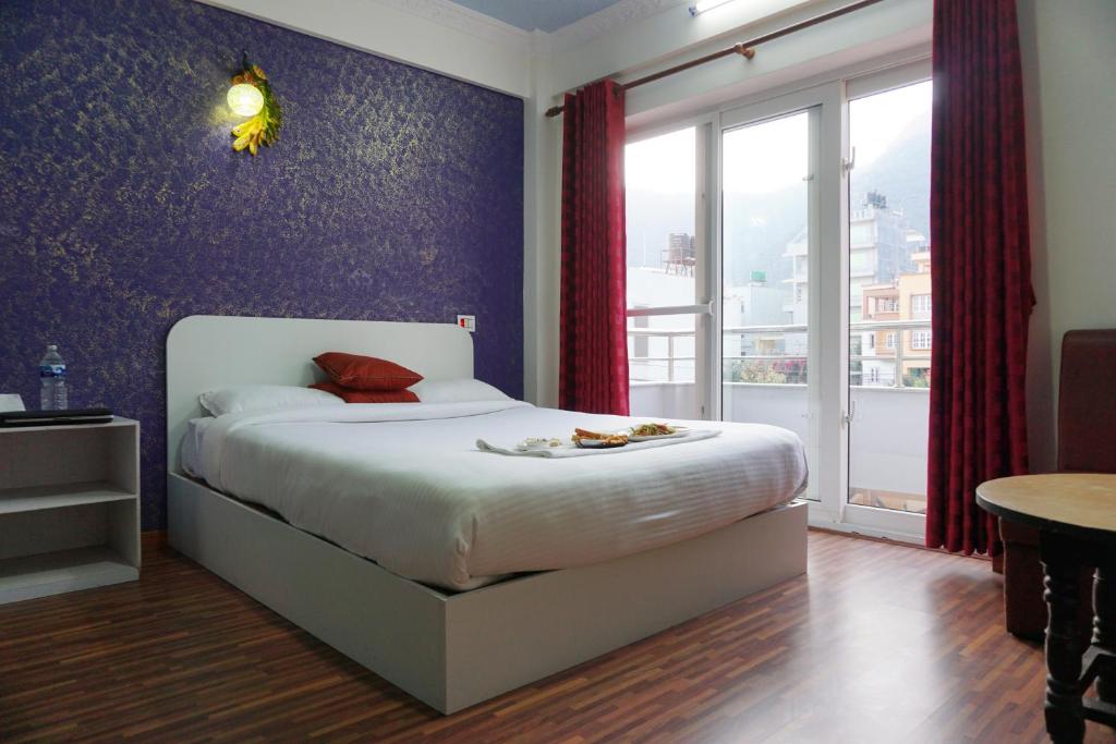 sypialnia z łóżkiem typu king-size i stołem w obiekcie Mount Star Homestay w Katmandu