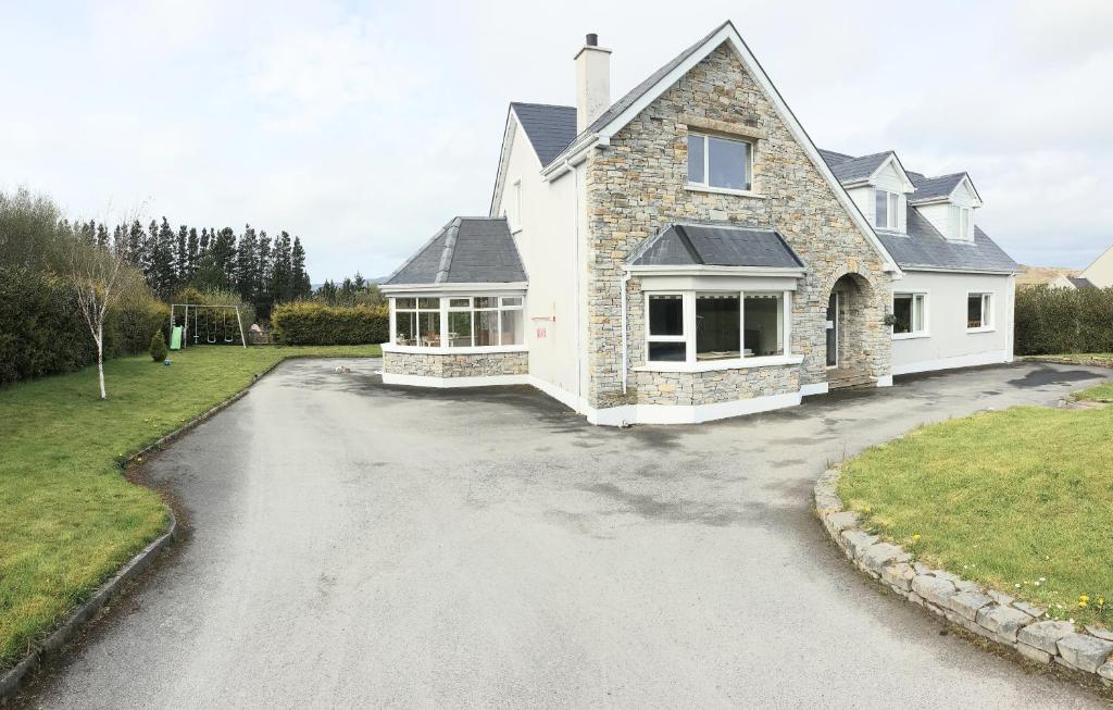 una entrada frente a una casa blanca en Large Buncrana Holiday Home - 2min drive to Beach, en Garrynabullogy