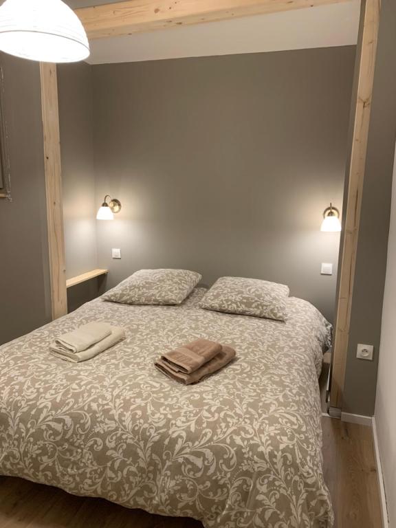 1 dormitorio con 1 cama con 2 toallas en Gîte du clocher dans ancienne maison du vignoble en Niedermorschwihr