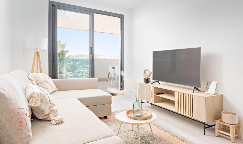 ein Wohnzimmer mit einem Sofa und einem Flachbild-TV in der Unterkunft Perfect apartment 3 - TCM in Fuengirola