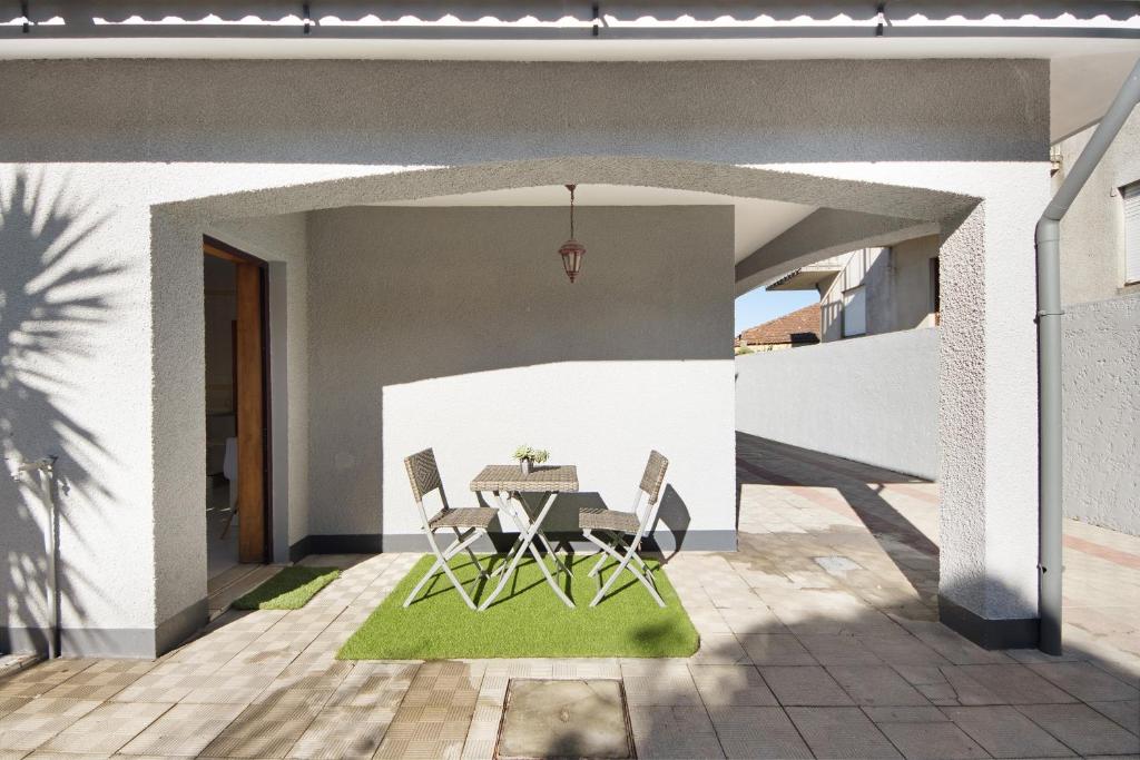 eine Terrasse mit einem Tisch und Stühlen auf einer Terrasse in der Unterkunft Gilove House in Póvoa de Varzim