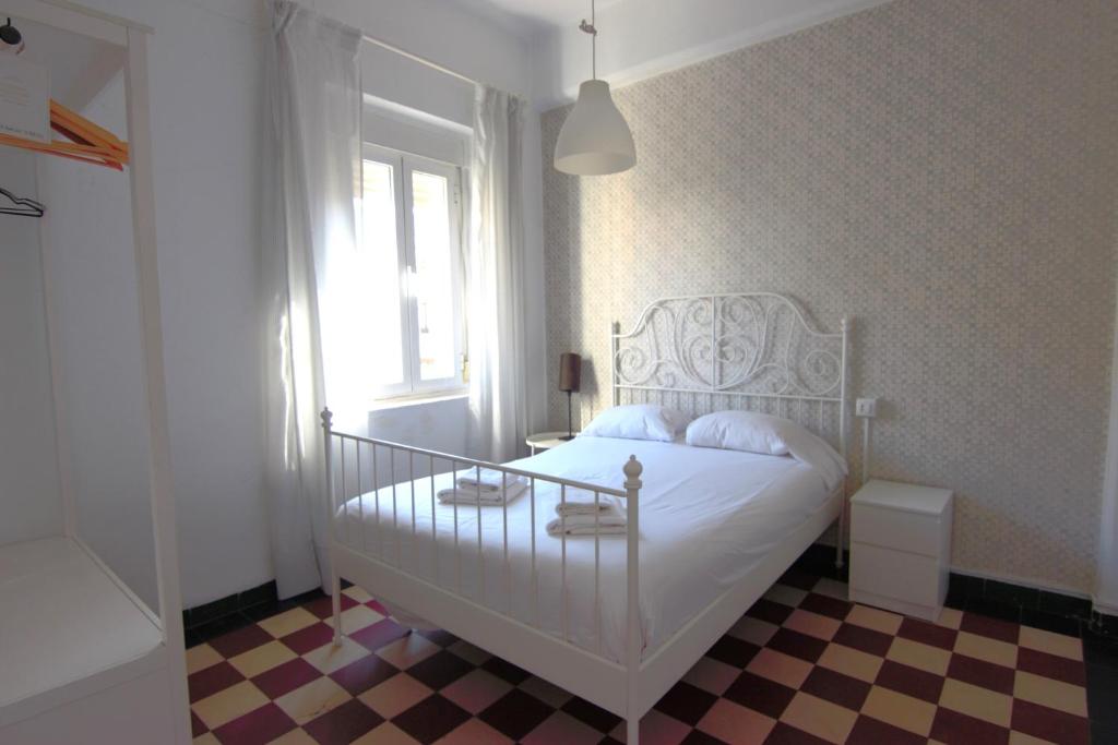 um quarto com uma cama branca e uma janela em RentalSevilla cerca del Salvador em Sevilha