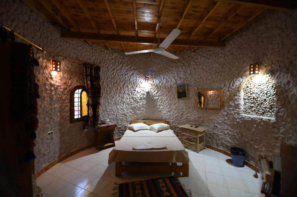 um quarto com uma cama e uma ventoinha de tecto em Dream Lodge Siwa دريم لودج سيوة em Siwa