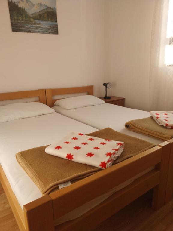 dwa łóżka z ręcznikami na nich w sypialni w obiekcie Apartmani Mile w Krku