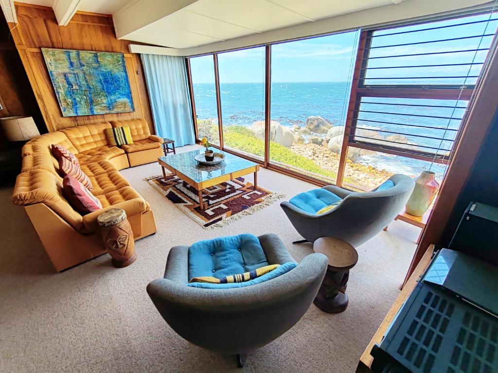 a living room with a view of the ocean at Timber's Ocean House in Simonʼs Town