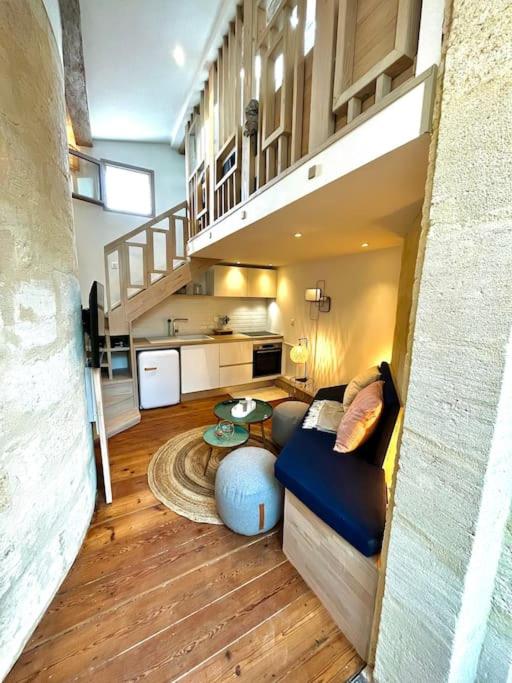 - un petit salon avec un canapé et un escalier dans l'établissement T1 Bis au coeur du centre historique, à Bordeaux