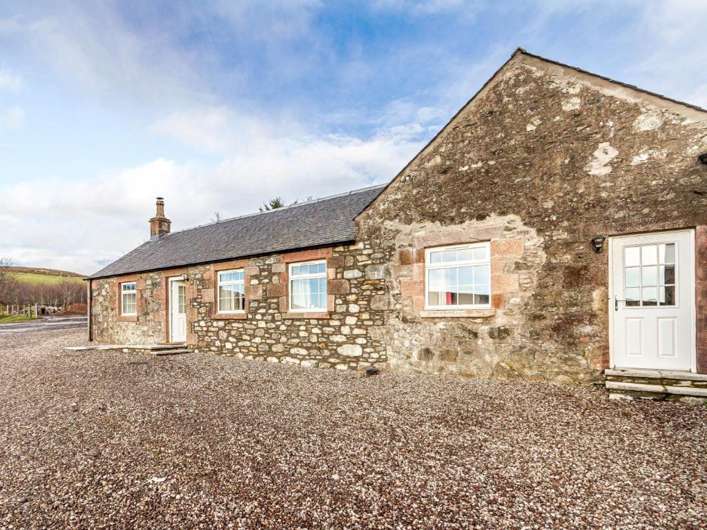 an old stone house with a gravel driveway at 2 Bed in Kirriemuir 80719 in Pearsie