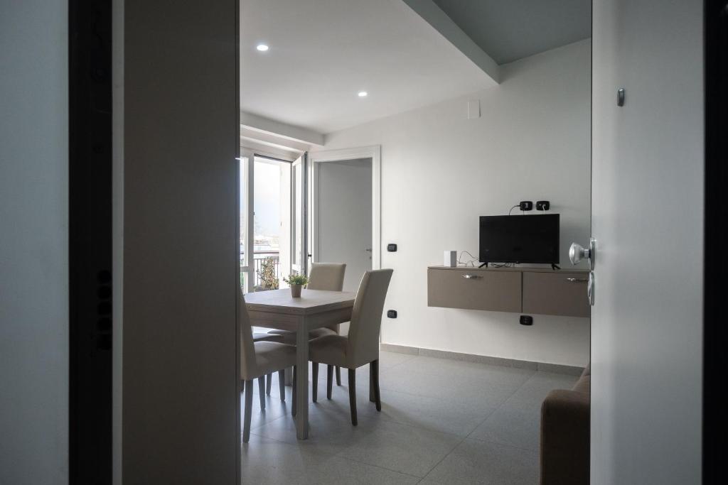 uma sala de jantar com uma mesa e cadeiras e uma televisão em Strategic Apartment with Terrace - Nola em Nola