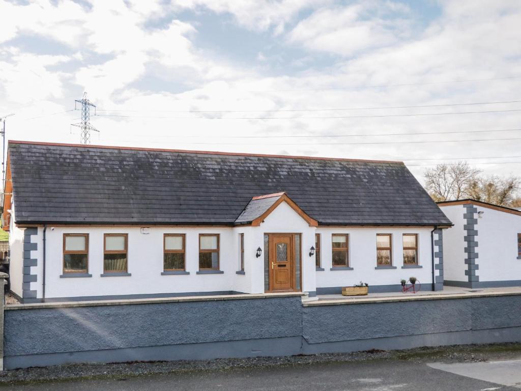a white house with a black roof at The Garden Cottage in Crossmaglen