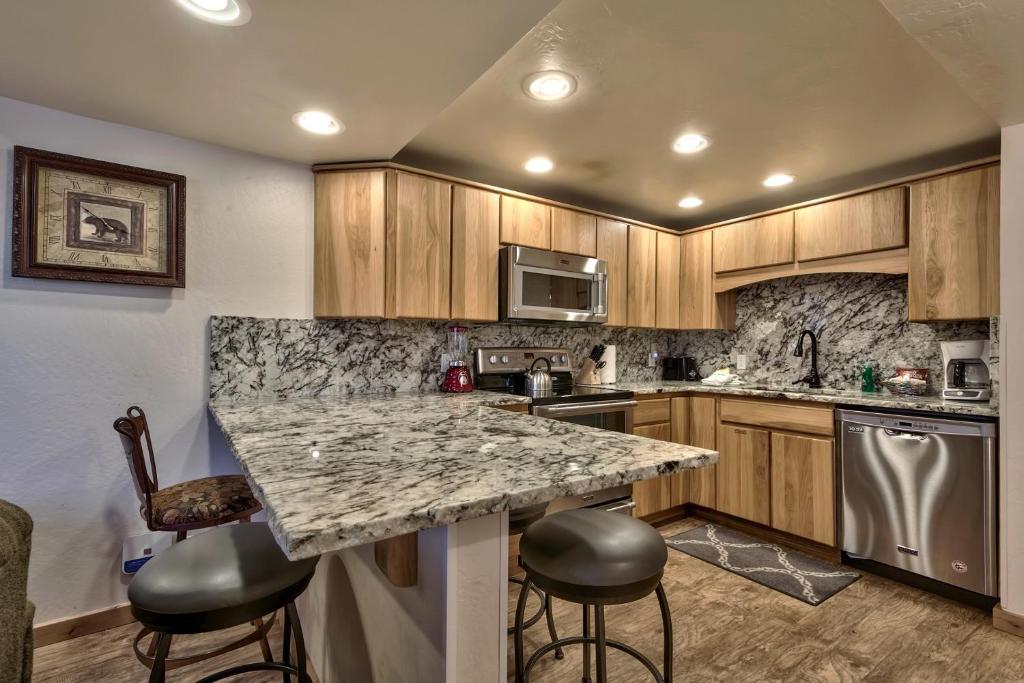 a kitchen with a marble counter top and wooden cabinets at Lakeland Village at Heavenly in South Lake Tahoe