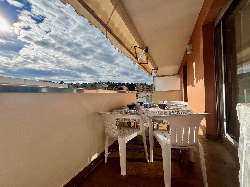 cocina con mesa, sillas y ventana en Appartement Cavalaire-sur-Mer, 2 pièces, 4 personnes - FR-1-226B-178, en Cavalaire-sur-Mer