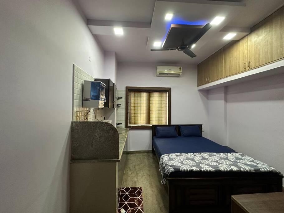 um quarto com uma cama azul e uma janela em Amazing AC Studio in E City 3F 302 em Bangalore