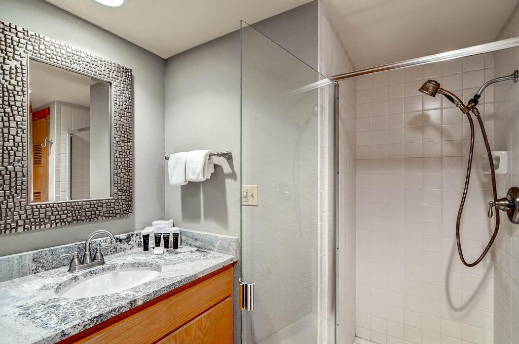 een badkamer met een douche, een wastafel en een spiegel bij Lakeside Village by Keystone Resort in Keystone