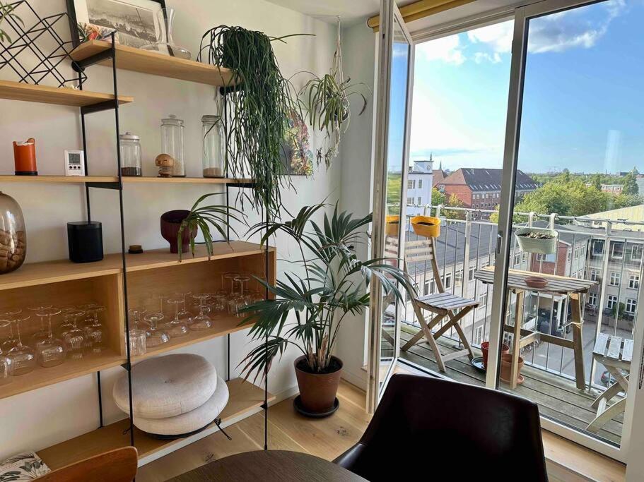 a room with shelves with plants and a balcony at Penthouse: Copenhagen delight in Copenhagen