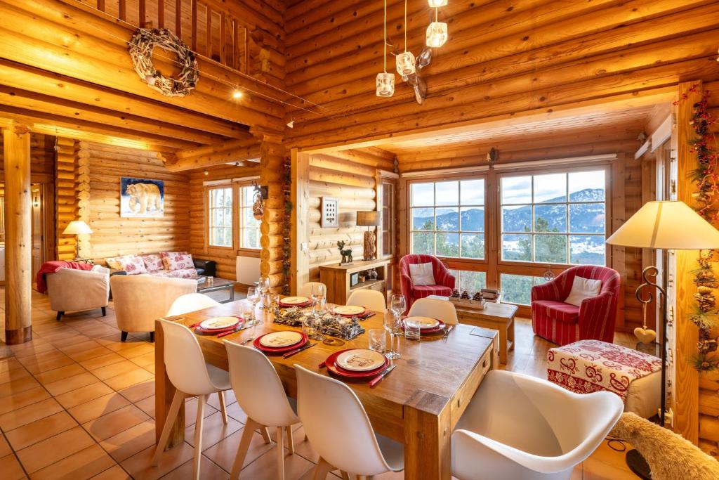 a dining room and living room with a table and chairs at Le Chalet des Ours - Superbe chalet 4 étoiles in Les Angles